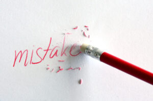 A pencil eraser erasing a portion of the word, "mistake"