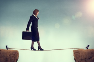 Businesswoman walking on tight rope.